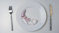 Knife and fork, measuring tape on a plate on a white background. Diet concept