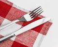 Knife and fork on red checked tablecloth