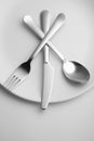 Knife, fork and spoon on white plate Royalty Free Stock Photo