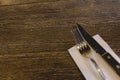 Knife and fork on a wood table with white napkin Royalty Free Stock Photo