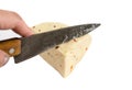 Knife in hand cuts a piece of hard cheese on a white background. Ukrainian cheese with spices and vegetables. Close-up. Royalty Free Stock Photo