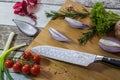 Knife with healthy food - vegetables, onion, salad, tomatoes, potato placed on a cutting board with wood background top view Royalty Free Stock Photo