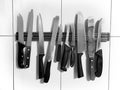 Knife magnet on the wall, many different knives; vintage, grunge, black and white concept Royalty Free Stock Photo