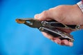 Metal knife multitool turned into pliers in the hands of a man Royalty Free Stock Photo