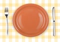 Knife, orange plate and fork on checked top view