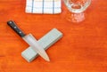 Knife sharpen with whetstone paste on wooden table Royalty Free Stock Photo