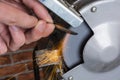 Knife sharpener and hand with blade on wooden table, closeup Royalty Free Stock Photo