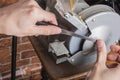 Knife sharpener and hand with blade on wooden table, closeup Royalty Free Stock Photo