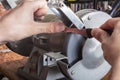 Knife sharpener and hand with blade on wooden table, closeup Royalty Free Stock Photo