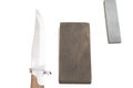 knife sharpening, knife on isolated white background with abrasive stone. Royalty Free Stock Photo