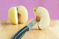 Knife stabbed into chinese pear piece on the wooden board