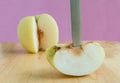 Knife stabbed into chinese pear on the wooden board