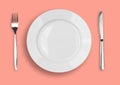 Knife, white plate and fork on pink background Royalty Free Stock Photo