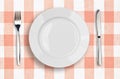 Knife, white plate and fork on pink tablecloth