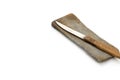 A knife with a wooden handle lays atop a gray sharpening stone, angled in the top right corner of the frame Royalty Free Stock Photo