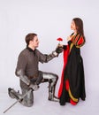 Knight in armor gives a young woman in a medieval dress a rose flower. Fantasy illustration for a book novel Royalty Free Stock Photo