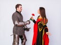 Knight in armor gives a young woman in a medieval dress a rose flower. Fantasy illustration for a book novel Royalty Free Stock Photo