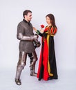 Knight in armor gives a young woman in a medieval dress a rose flower. Fantasy illustration for a book novel Royalty Free Stock Photo