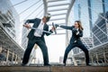 Knight businessman and boxer businesswoman fighting war on city Royalty Free Stock Photo