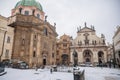 Knight of the Cross Square near Charles Bridge under snow in winter day, Baroque Church of St. Francis of Assisi and Church of the