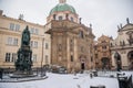 Knight of the Cross Square near Charles Bridge under snow in winter day, Baroque Church of St. Francis of Assisi and Church of the