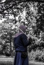 a knight in light armor with a sword resting on his neck.  Black and white photo with blue Royalty Free Stock Photo