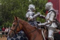 Knight`s greeting. Two knights in steel armor and on horses greet each other