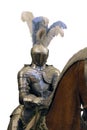Knight in shining steel armor and a helmet with feathers on the horse isolated