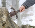 Knight tries to remove Excalibur sword in the stone Royalty Free Stock Photo