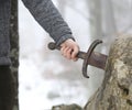 Knight tries to remove Excalibur sword in the stone Royalty Free Stock Photo