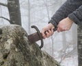 Knight tries to remove Excalibur sword in the stone Royalty Free Stock Photo