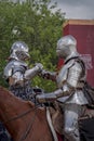 Knights greeting each other. Knightly tournament, historical reenactment of Middle Ages. Knights salute on horses.