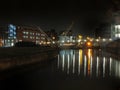 Knights Way Footbridge crossing the river aire at the lock entrance to clarence dock in leeds at night with buildings and lights Royalty Free Stock Photo