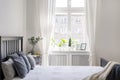 Knit blanket and pillows on bed in white hotel bedroom interior