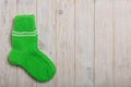 Knit green wool socks on light wooden background. Royalty Free Stock Photo