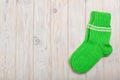 Knit green wool socks on wooden background light. Royalty Free Stock Photo