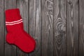 Knit red wool socks on dark wooden background.