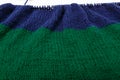 Knit striped green blue fabric on knitting needle in process. Texture, background. Textile, sweatshirt or sweater textured surface Royalty Free Stock Photo