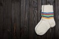 Knit white wool socks on dark wooden background. Royalty Free Stock Photo