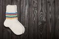 Knit white wool socks on dark wooden background. Royalty Free Stock Photo