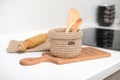 knit woven basket with wooden kitchenware. eco home. housekeeping and householding. white table and zero waste no