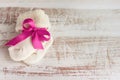 Knitted baby socks with pink bow on the wooden surface Royalty Free Stock Photo