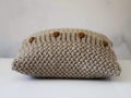 Knitted beige pillow with wooden buttons