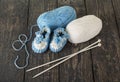 Knitted booties for baby, white and blue skein of wool yarn Royalty Free Stock Photo