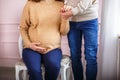 Knitted booties in the hands of a pregnant woman next to her husband. waiting for a miracle Royalty Free Stock Photo