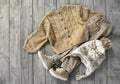 Knitted cardigan, brown jeans and hat flat lay on wooden background. Baby autumn clothes. Boy`s apparel set.Beige garment.Child`