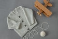 Knitted children`s cardigan with a ball of natural yarn on a gray background with a wooden toy in retro style, baby  layout Royalty Free Stock Photo