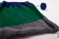 Knitted clothing, accessory in process of making. Knitting needles and ball of threads, yarn on white background. Striped blue,