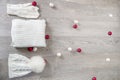 Knitted cold weather accessory near new year tree balls on the table. White hat, scarf ant gloves grey wooden background. Top vie Royalty Free Stock Photo