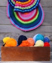 Knitted colorful striped mats and balls of bright woolen yarn in a wooden box on old wood wall background Royalty Free Stock Photo